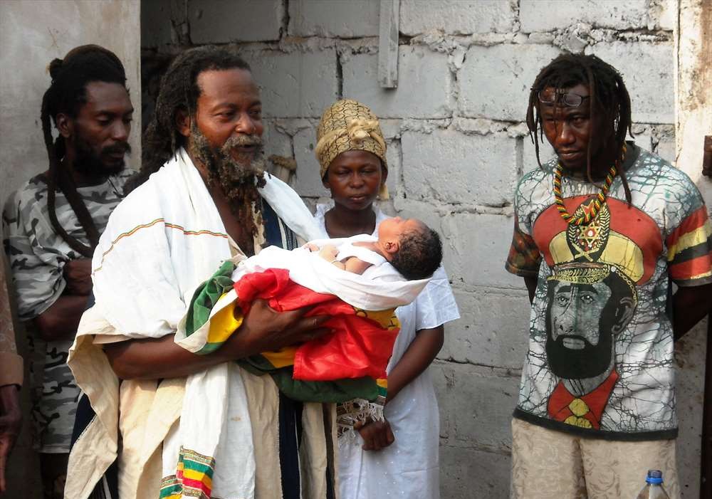 a rastafarian priest with a newly born child
